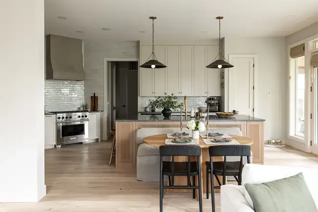 Whole-home remodel kitchen in Camas, WA with white shaker uppers, wood island, black pendants and dining table